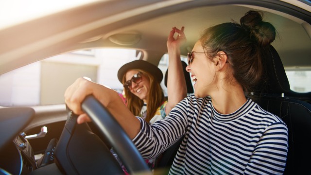 Bis zu 15 % Rabatt bei Europcar sichern! junge Frauen feiern im Auto
