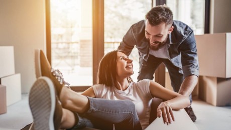 Europcar Autovermietung. Moving your way. junges Paar spielt mit leeren Umzugskisten