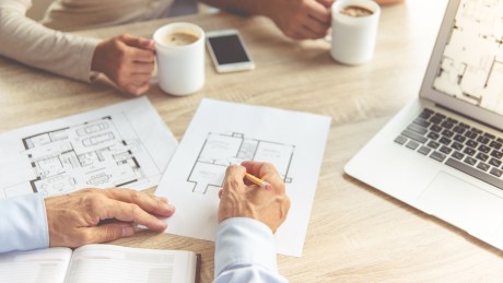 Ein Berater von Wüstenrot Immobilien plant mit Kunden den Grundriss deren Hauses