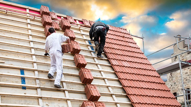 Handwerker decken Hausdach ein
