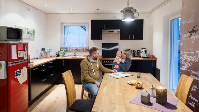 junge Familie sitzt in ihrer modernen Küche