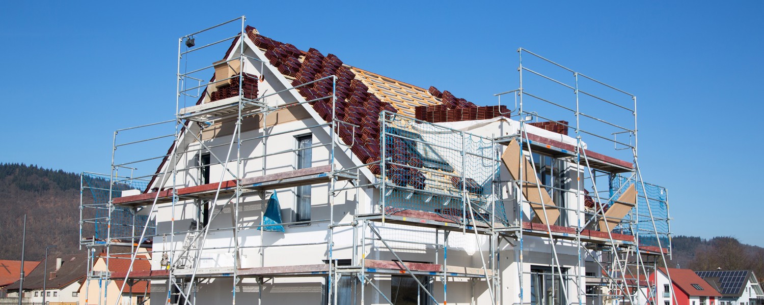 Mehrfamilienhaus mit Gerüst während des Hausbaus. Einfamilienhaus im Rohbau