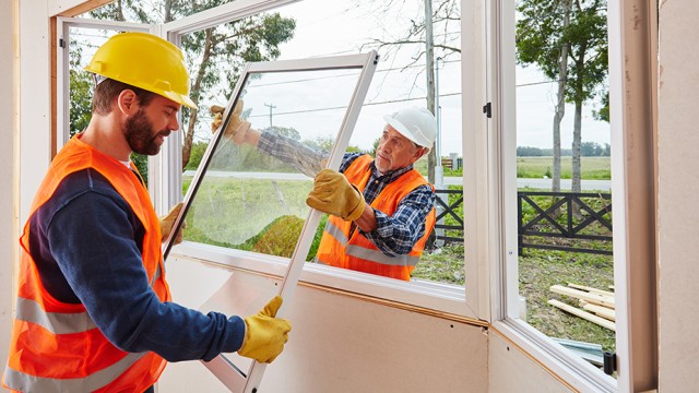 Handwerker bauen Fenster ein