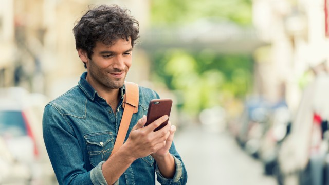 Ein Mann informiert sich auf seinem Handy zur Zuteilungsreife seines Bausparvertrages Ein Mann informiert sich auf seinem Handy zur Zuteilungsreife seines Bausparvertrages