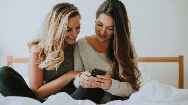 Wenn das erste Gehalt eintrifft, ist das gerade für junge Menschen ein großer Grund zur Freude zwei junge Frauen am Smartphone