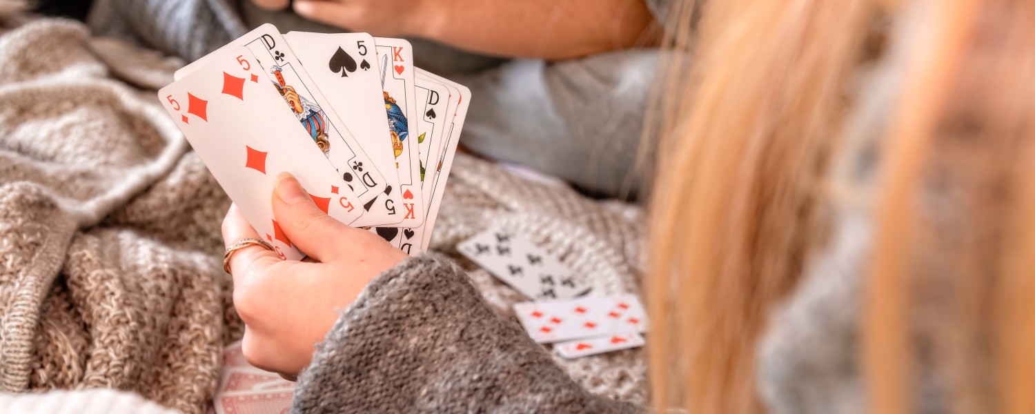 Eine Person hält Spielkarten in der Hand