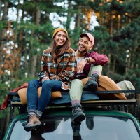 Ein junges Paar sitzt auf dem Dach ihres Campervans