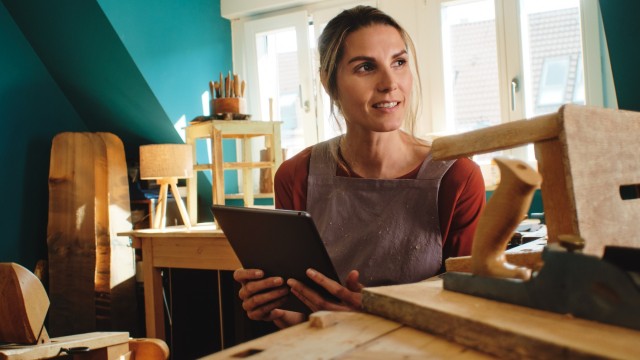 Eine Frau informiert sich auf ihrem Tablet zum Wüstenrot Top Festgeldkonto