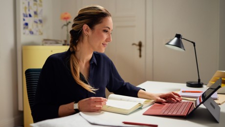 Eine Frau schließt einen Bausparvertrag auf ihrem Tablet online ab