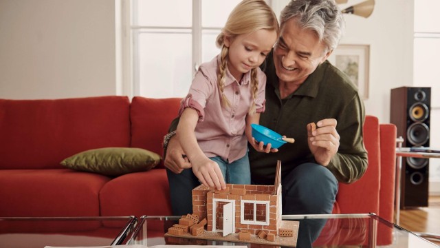 Großvater baut mit Enkelin ein Spielzeughaus