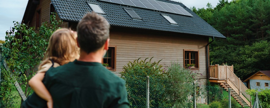 Vater und Tochter schauen auf ihr modernisiertes Haus, dass sie mit KfW-Förderung finanziert haben.