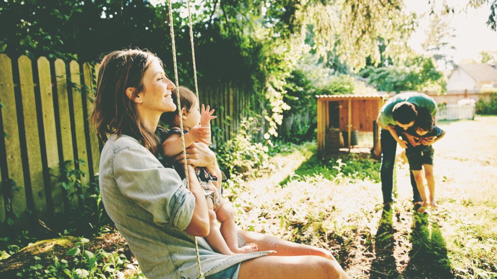 Eine junge Familie verbringt Zeit im Garten ihres Hauses, das mit einem Bausparvertrag finanziert wurde Eine junge Familie verbringt Zeit im Garten ihres Hauses, das mit einem Bausparvertrag finanziert wurde