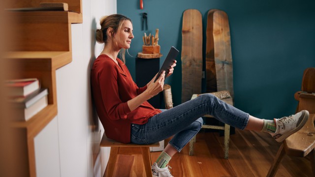 Eine Frau sucht eine Immobilie auf ihrem Tablet Eine Frau sucht eine Immobilie auf ihrem Tablet