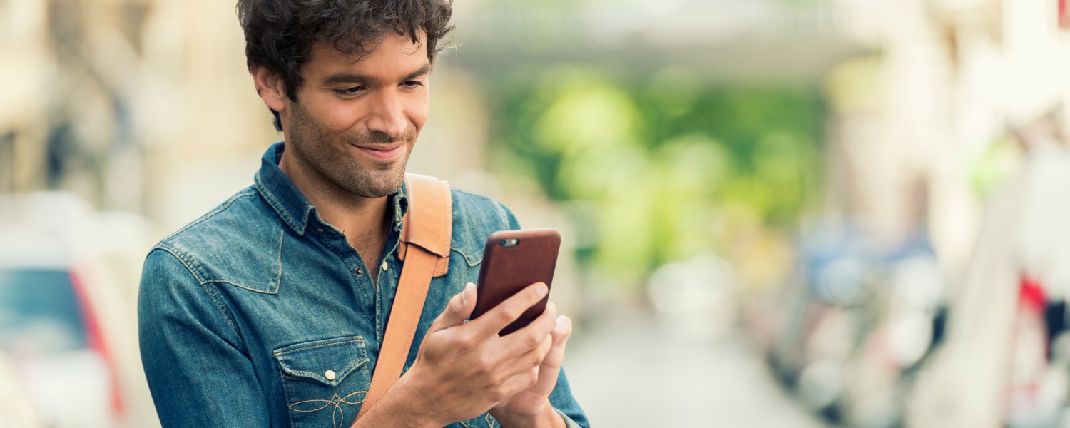 Ein Mann informiert sich auf seinem Smartphone über seine Tilgungsrate Ein Mann informiert sich auf seinem Smartphone über seine Tilgungsrate