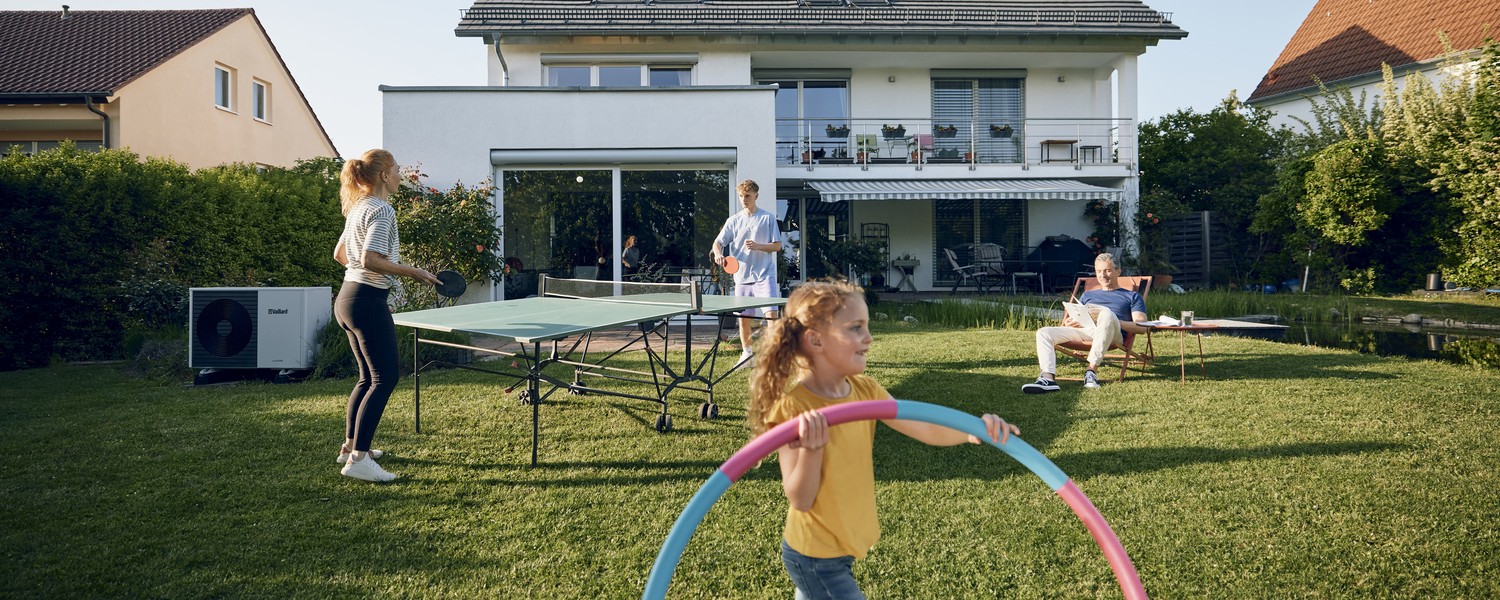 Eine Familie verbringt Zeit im Garten ihres Hauses, welches Sie mit einem Hypothekendarlehen finanziert haben Eine Familie verbringt Zeit im Garten ihres Hauses, welches Sie mit einem Hypothekendarlehen finanziert haben