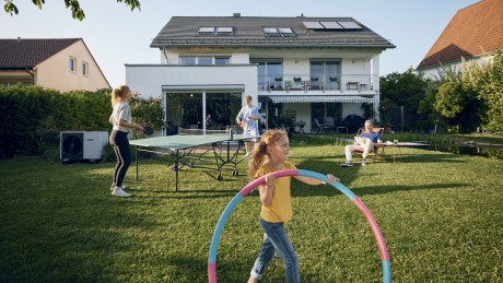 Baufinanzierung Familie spielt im Garten