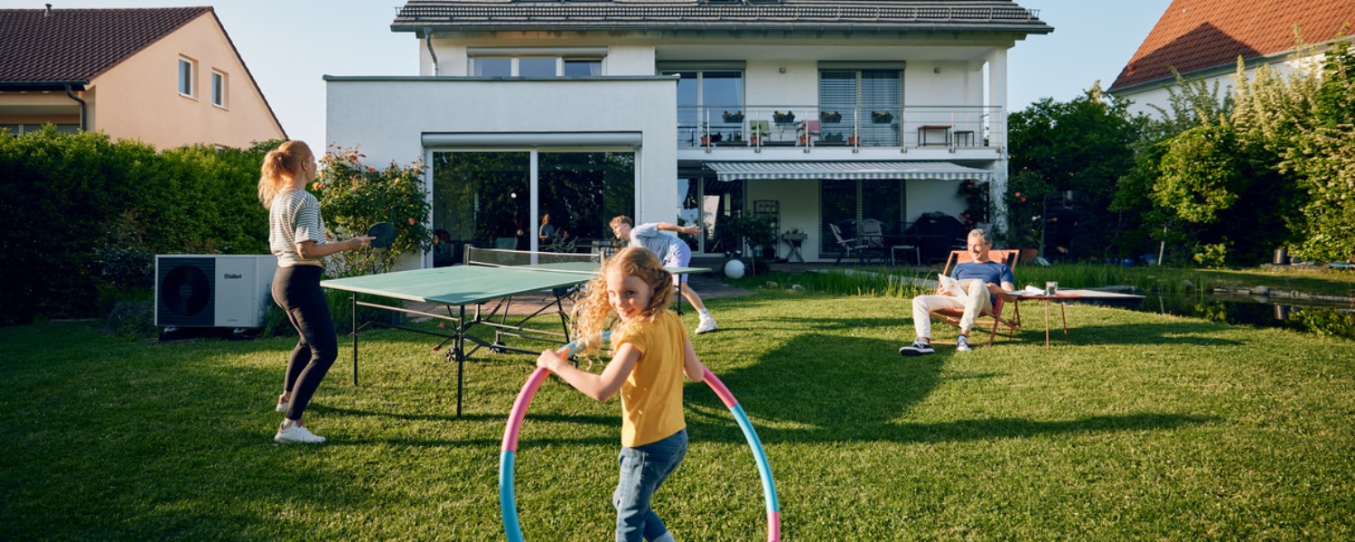 Eine Familie spielt im Garten Ihres Hauses, nachdem Sie kürzlich eine Modernisierung finanziert hat Eine Familie spielt im Garten Ihres Hauses, nachdem Sie kürzlich eine Modernisierung finanziert hat