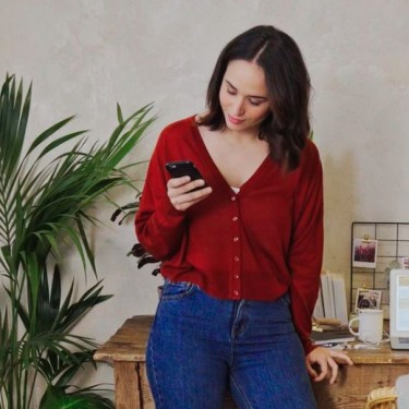 FinanzGuide - App herunterladen Frau mit Smartphone vor Arbeitsplatz